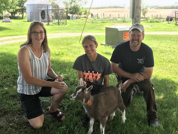 The 2018 IDGA Share-A-Kid program: Tim & Mary Schmidt of Schmidt/ECF have donated a Toggenburg doeling to Taylor McCreedy, age 14, of Cass County. Pictured left to right are Mary Schmidt, Taylor McCreedy, and Tim Schmidt, with doeling Kixify!